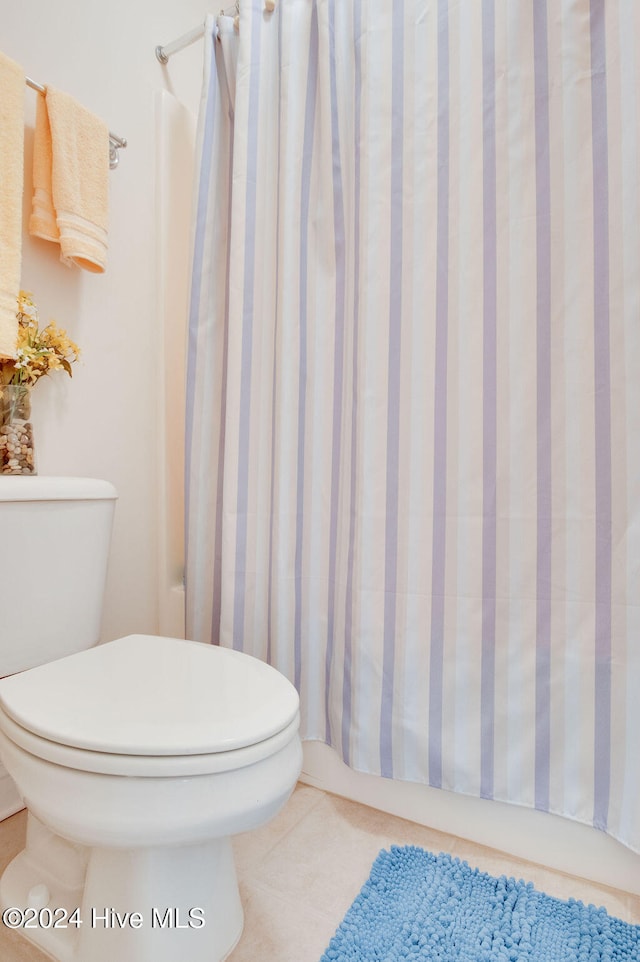 bathroom featuring tile patterned floors, toilet, and walk in shower