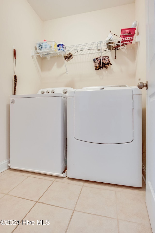 laundry area with washer and dryer and light tile patterned floors