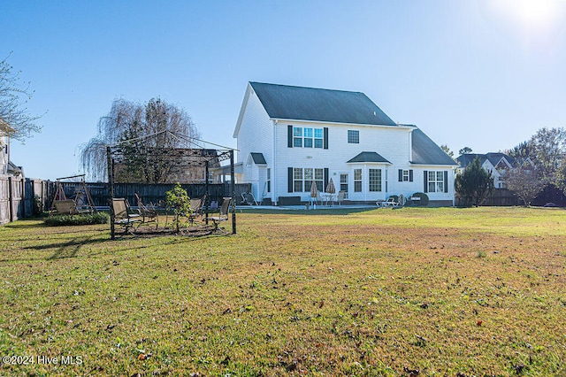 back of house with a gazebo, a trampoline, a patio area, and a yard