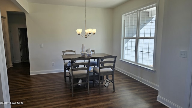 dining room with an inviting chandelier, baseboards, and dark wood-type flooring