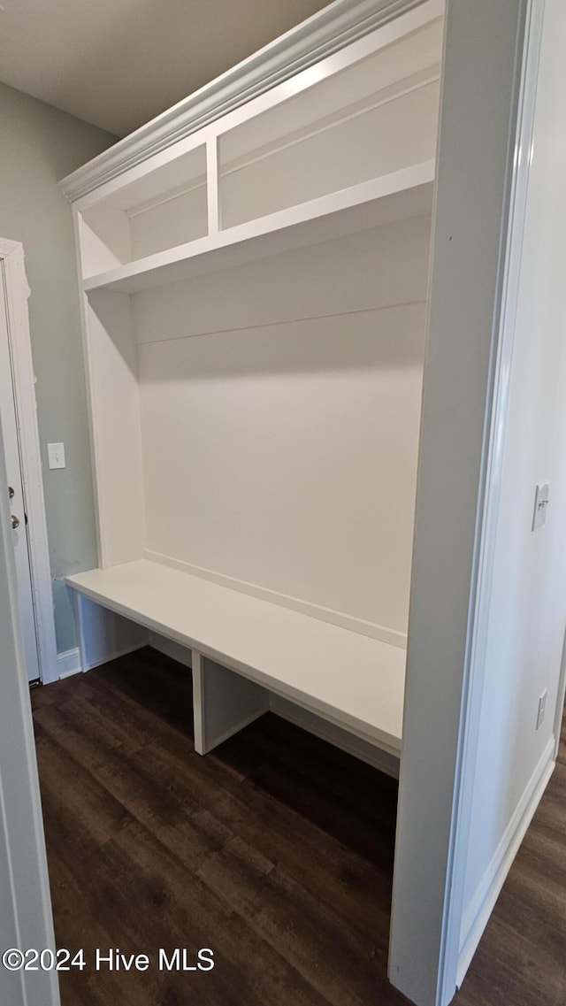 mudroom featuring dark wood-type flooring and baseboards