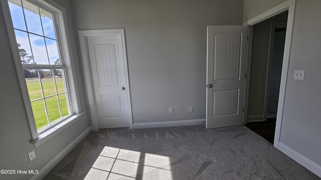 unfurnished bedroom featuring carpet flooring and baseboards