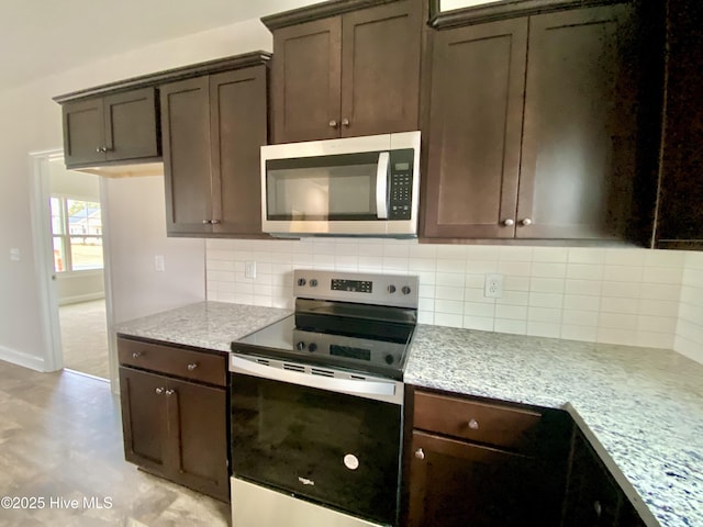 kitchen with light stone counters, tasteful backsplash, stainless steel appliances, and dark brown cabinetry