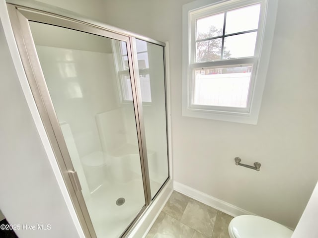 bathroom featuring toilet and an enclosed shower