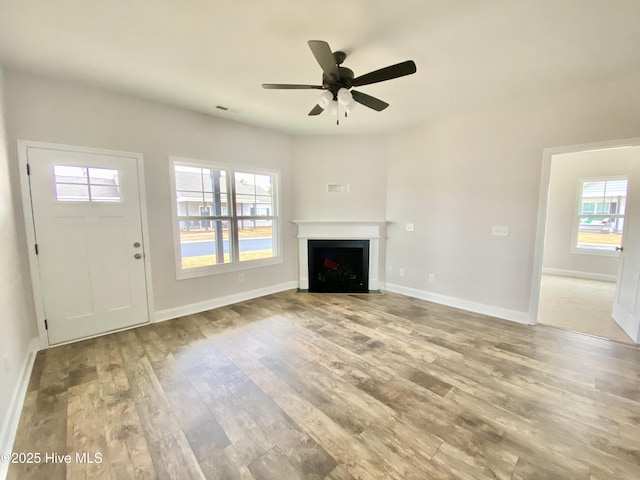 unfurnished living room with hardwood / wood-style flooring, ceiling fan, and plenty of natural light