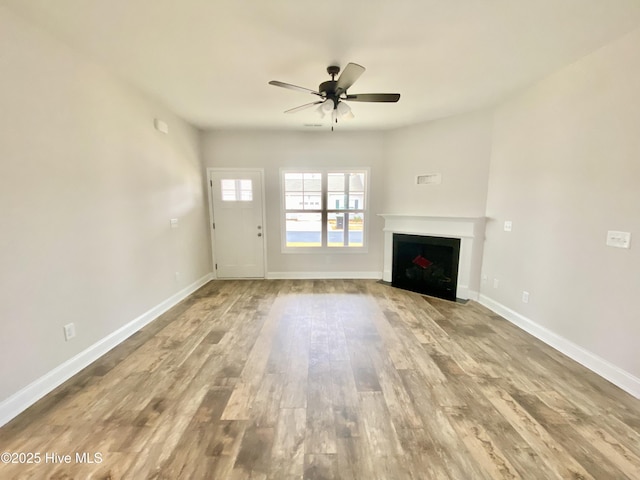 unfurnished living room with hardwood / wood-style flooring and ceiling fan