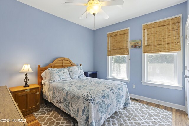 bedroom featuring a ceiling fan, a closet, baseboards, and wood finished floors