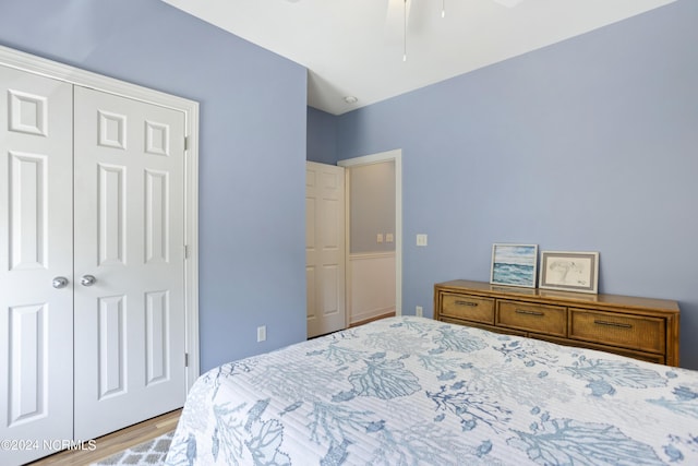 bedroom featuring light wood finished floors, a closet, and a ceiling fan