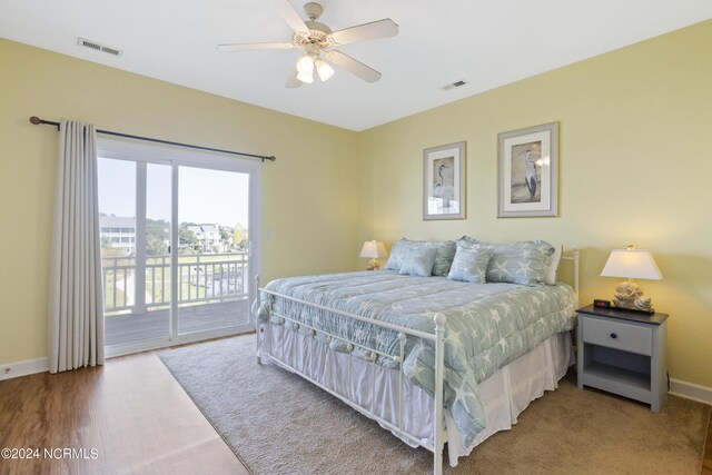 bedroom with ceiling fan, hardwood / wood-style floors, and multiple closets