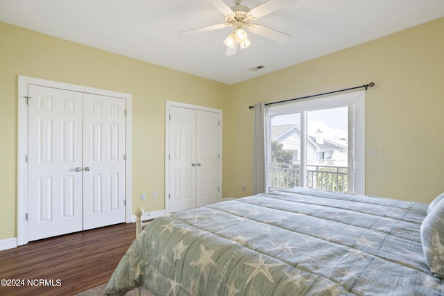 bedroom featuring ceiling fan, baseboards, multiple closets, and wood finished floors