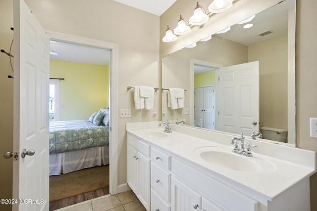 bathroom featuring a combined bath / shower with jetted tub, vanity, and tile patterned floors