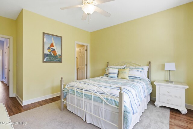 bedroom with baseboards, visible vents, ceiling fan, and wood finished floors