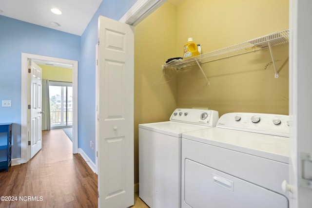 laundry room featuring washing machine and dryer and hardwood / wood-style floors