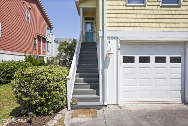 doorway to property with aphalt driveway and an attached garage