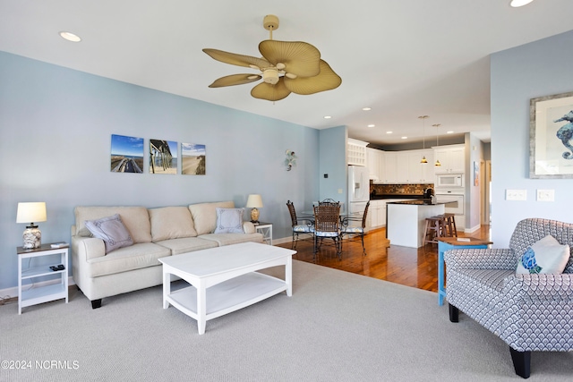 living room featuring dark wood-type flooring and ceiling fan