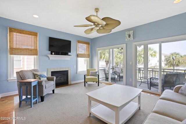 living room featuring ceiling fan and a fireplace