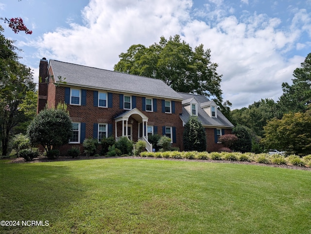 colonial home featuring a front lawn