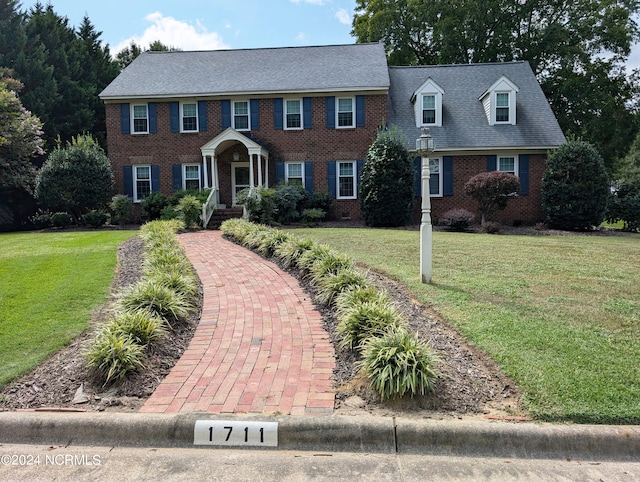 colonial home featuring a front lawn