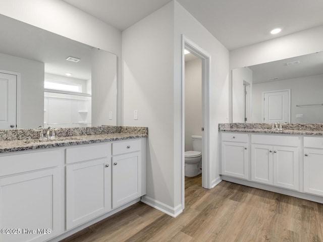 bathroom with toilet, hardwood / wood-style flooring, and vanity