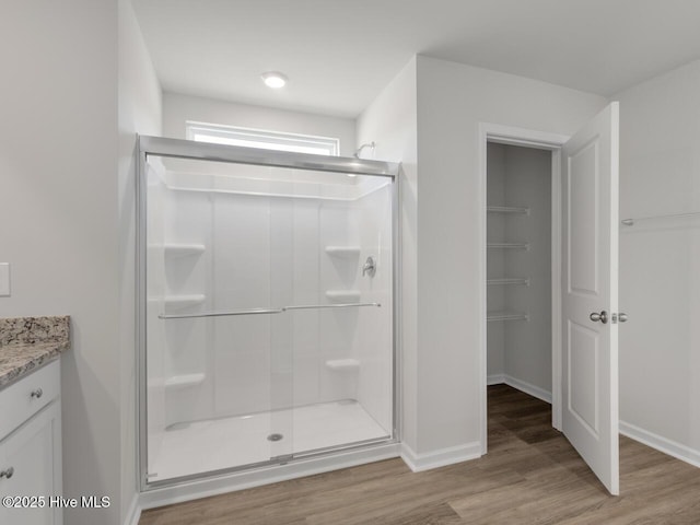 bathroom with vanity, hardwood / wood-style flooring, and a shower with door