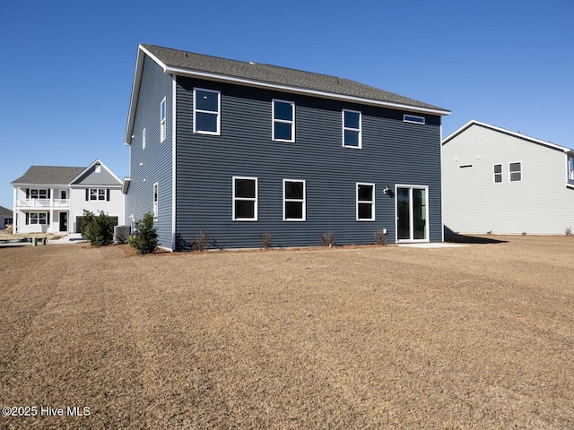 back of property featuring cooling unit and a yard