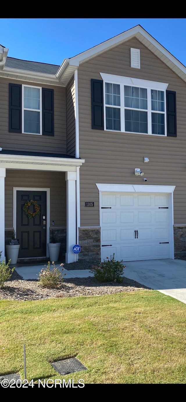 view of front of property featuring a front yard and a garage