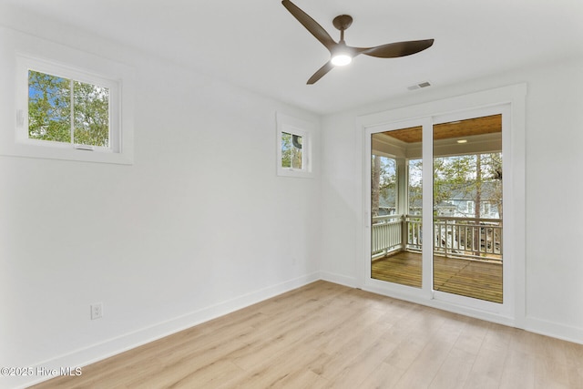 empty room featuring ceiling fan, a healthy amount of sunlight, and light wood-type flooring