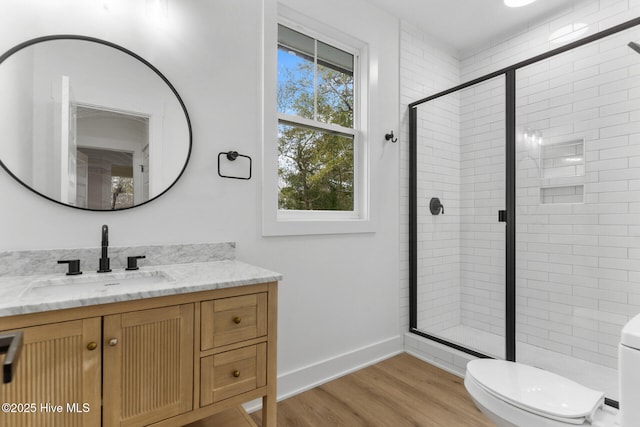 bathroom with vanity, wood-type flooring, toilet, and walk in shower