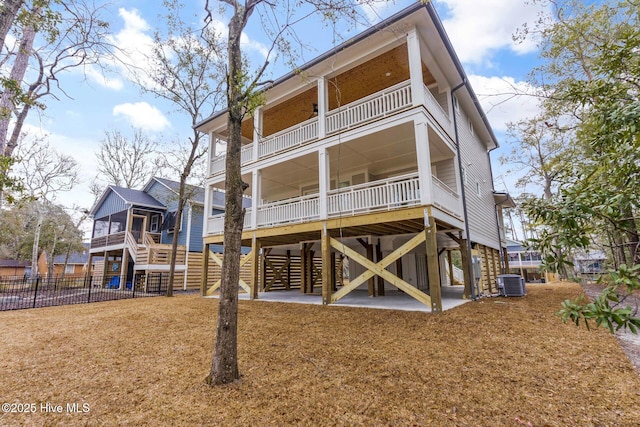 rear view of property featuring a balcony, a sunroom, and central air condition unit