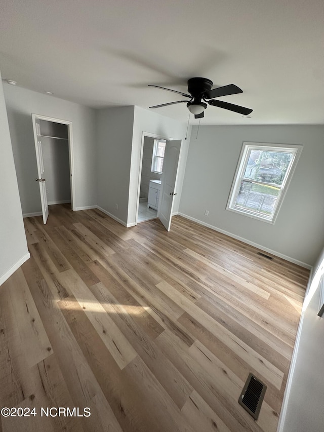 unfurnished bedroom with ceiling fan, light wood finished floors, visible vents, and baseboards