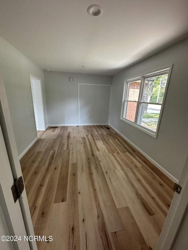 unfurnished bedroom featuring light wood-style floors and baseboards