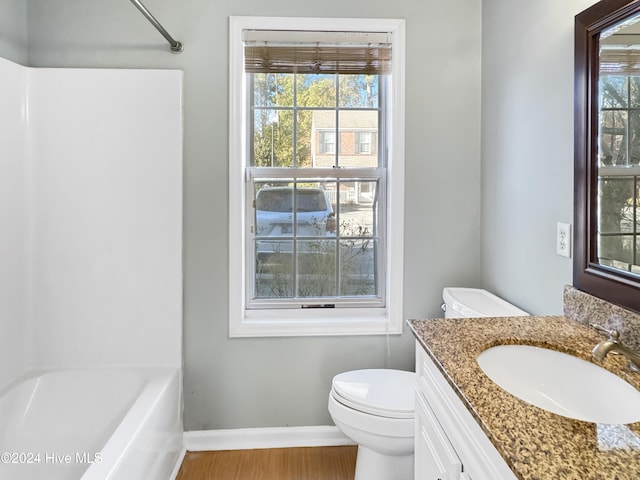 bathroom with hardwood / wood-style floors, vanity, toilet, and a wealth of natural light