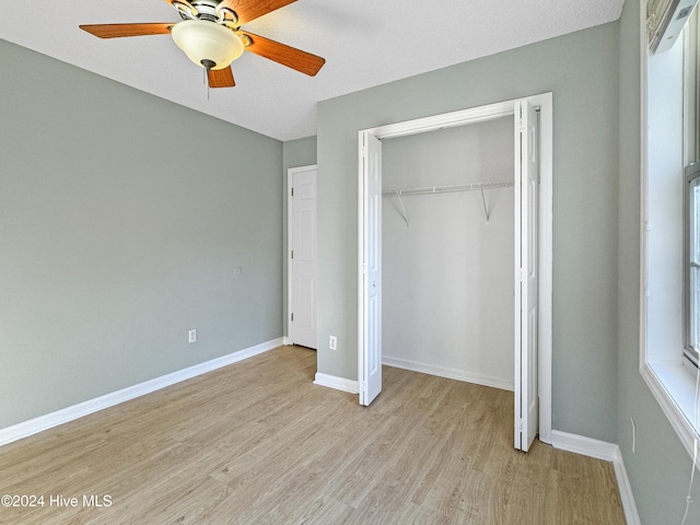 unfurnished bedroom with a closet, light hardwood / wood-style flooring, and ceiling fan