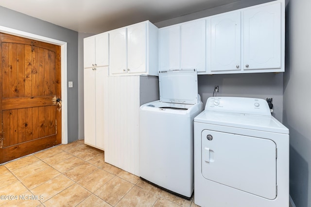 laundry area with light tile patterned flooring, cabinets, and separate washer and dryer