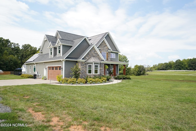 craftsman-style home featuring solar panels, a garage, and a front lawn