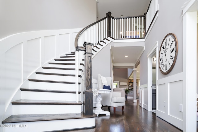 foyer entrance featuring crown molding and dark wood-type flooring