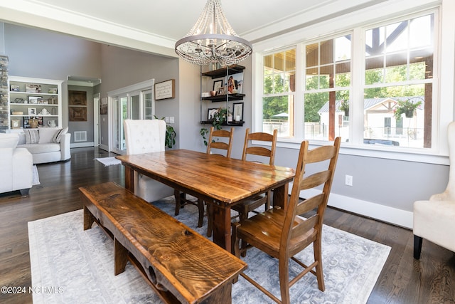 dining room featuring dark hardwood / wood-style floors, built in features, a notable chandelier, and crown molding