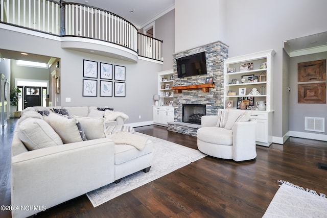 living room with dark hardwood / wood-style floors, a stone fireplace, ornamental molding, and a high ceiling