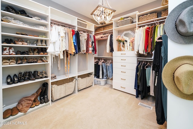 walk in closet with light carpet