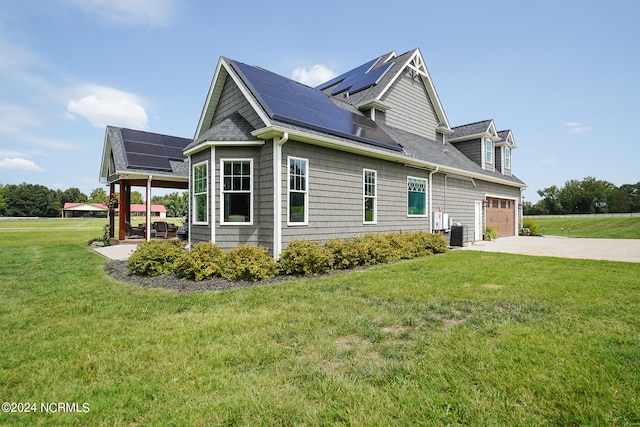 view of side of property featuring central AC unit, solar panels, a garage, and a yard