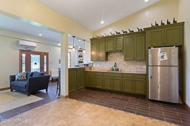 kitchen with tasteful backsplash, sink, decorative light fixtures, an AC wall unit, and stainless steel refrigerator