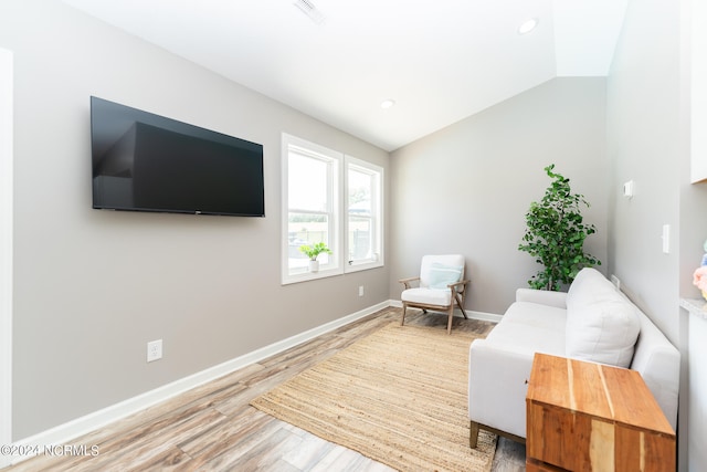 living area featuring wood-type flooring and vaulted ceiling