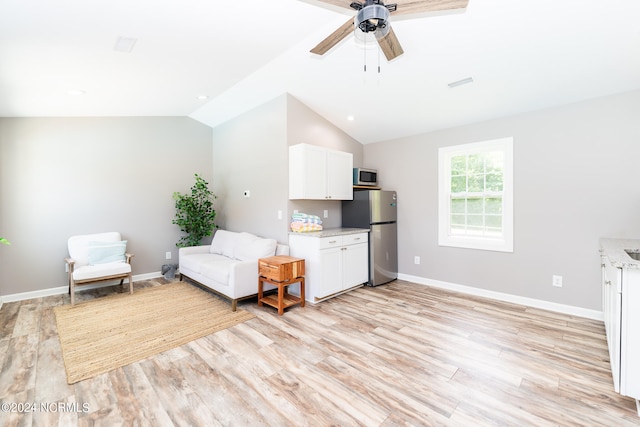 sitting room with ceiling fan, light hardwood / wood-style flooring, and vaulted ceiling