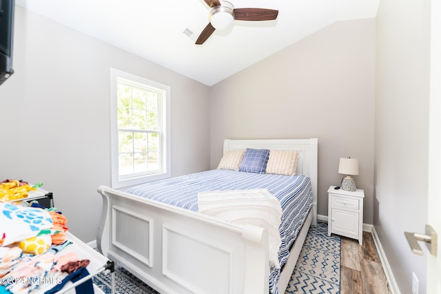 bedroom with light hardwood / wood-style floors, vaulted ceiling, and ceiling fan