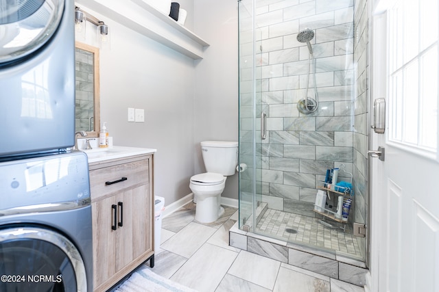 bathroom featuring vanity, stacked washing maching and dryer, a shower with shower door, and toilet