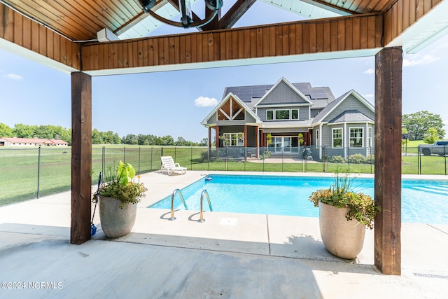 view of pool featuring a lawn, ceiling fan, and a patio