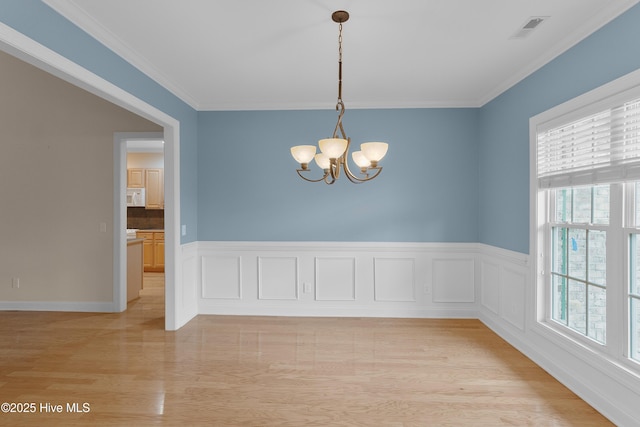 2788 Creek Bridge Ct, Southport, NC 28461 - unfurnished room featuring a chandelier, light wood-style flooring, crown molding, and wainscoting