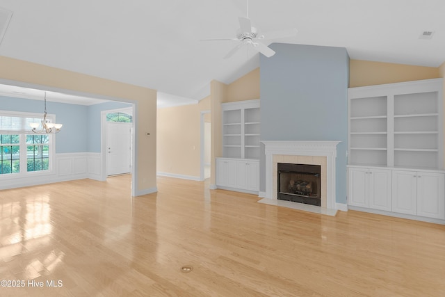 2788 Creek Bridge Ct, Southport, NC 28461 - unfurnished living room with lofted ceiling, a tile fireplace, wainscoting, a ceiling fan, and light wood-style floors