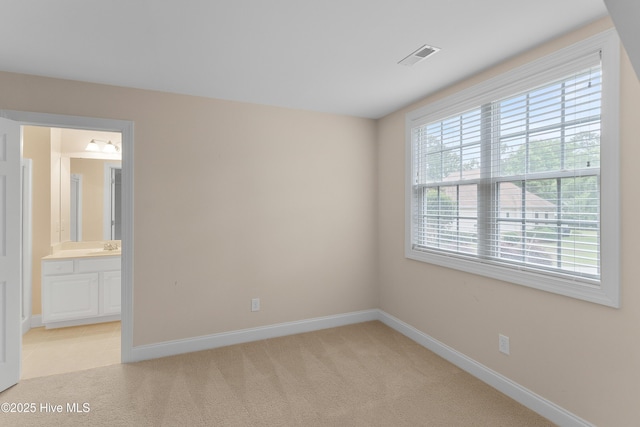 2788 Creek Bridge Ct, Southport, NC 28461 - unfurnished bedroom featuring baseboards, light colored carpet, and connected bathroom