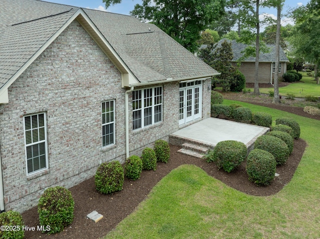 2788 Creek Bridge Ct, Southport, NC 28461 - rear view of house with brick siding, a yard, a patio, french doors, and a shingled roof